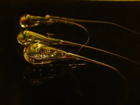 rupert's drop: a glass bead created by dripping molten glass into cold water so it solidifies into a tadpole shape...