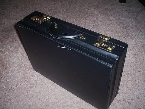 attaché case: a box-style briefcase, scrunched over a hinged frame that opens into two compartments