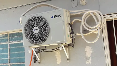 air conditioner: a machine that is used to control temperature and humidity in an enclosed space