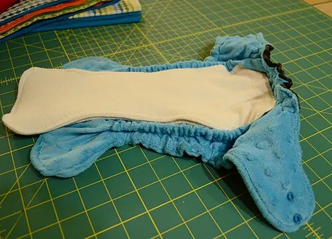 all-in-two diaper: a type of cloth diaper, similar to a pocket diaper, that has a waterproof exterior and absorbent...