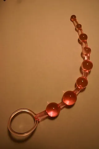anal beads: a sex toy consisting of several small balls attached together in series which are one by one...