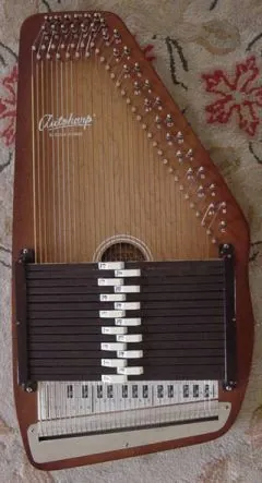 autoharp: a string instrument having a series of chord bars attached to dampers (muting bars) which mute all...