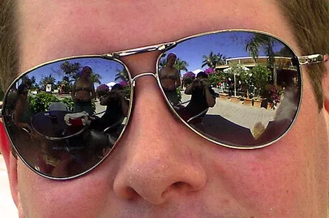 aviator sunglasses: a style of sunglasses with dark, often reflective lenses and very thin metal frames