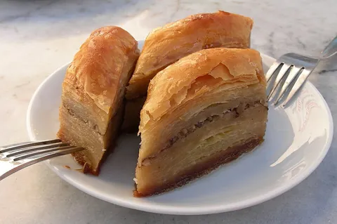 baklava: a sweet pastry found in many cuisines of the Middle East and the Balkans, made of chopped nuts...