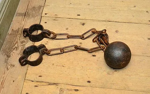 ball and chain: a heavy iron ball attached to a prisoner's leg by a chain as a means of restraint