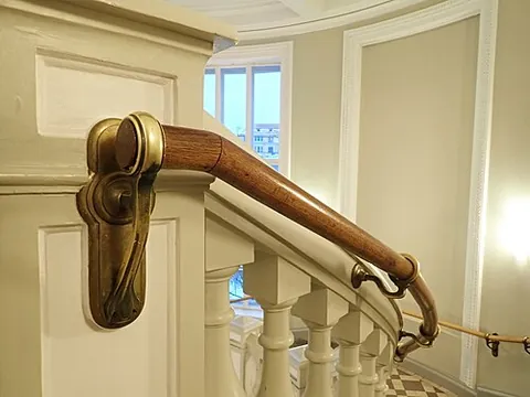 banister: the rail on the side of a staircase that a person's hand holds onto