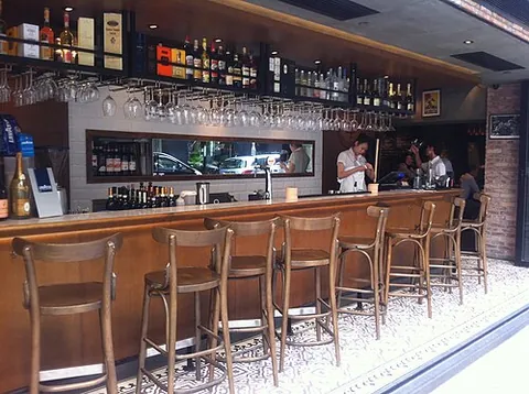 bar chair: a tall chair-like seat usually having a foot rest, commonly placed in bars and in front of kitchen...