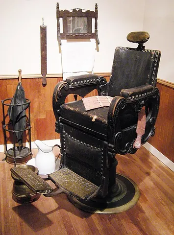 barber chair: an articulating chair used in barbershops and salons to facilitate hair-cutting and styling or...