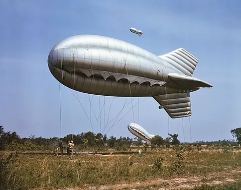 barrage balloon: a tethered balloon, attached to the ground with a metal cable, intended to deter low-flying enemy...