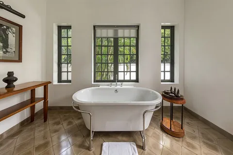bathtub: a large container for holding water in which a person may bathe (take a bath)