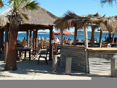 beach bar: a retail business that sells drinks and food on or by a beach
