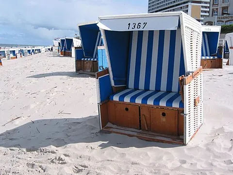 beach chair: a special chair designed to provide comfort and protection from sun, wind, rain, and sand on...