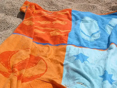 beach towel: a towel for use at the beach, typically larger than a normal household towel so that a person can...