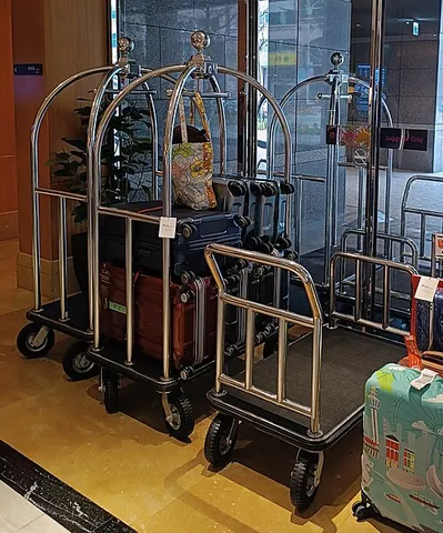 bell cart: a cart, typically with two walls, used within a hotel to move a guest's luggage between the parking...