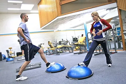 bosu ball: a piece of exercise equipment with an inflated rubber dome attached to a rigid flat platform, used...