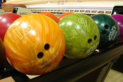 bowling ball: a solid ball used in the sport of bowling, with finger holes allowing it to be picked up