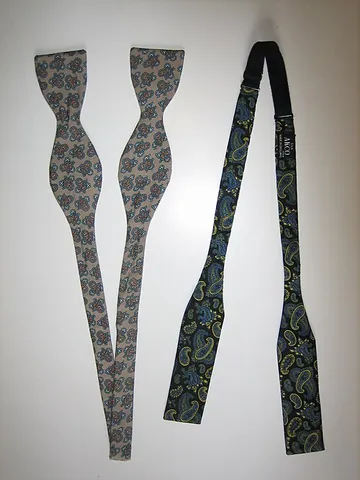 bowtie: a man's necktie tied in a bow around the throat