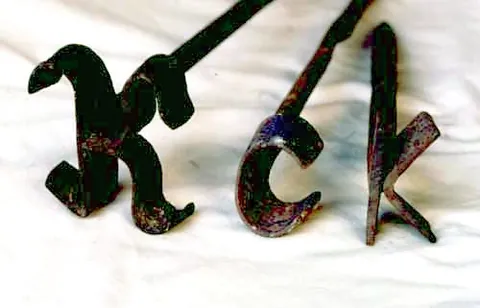 branding iron: a piece of metal bent into a distinctive shape, heated and used to brand livestock