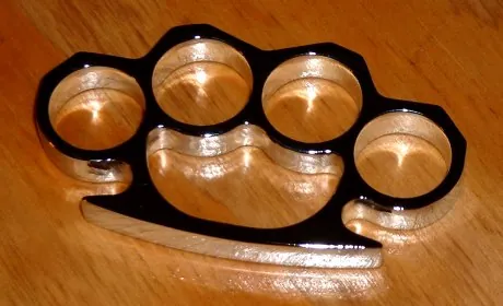brass knuckles: a weapon consisting of a metal reinforcement for the clenched fist, with finger holes molded in