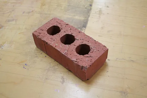 brick: a hardened rectangular block of mud, clay etc., used for building