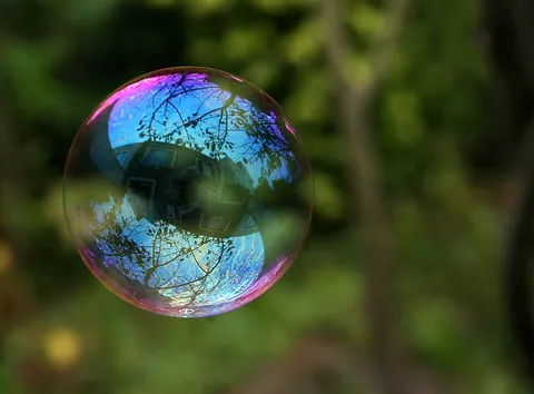 bubble: a spherically contained volume of air or other gas in a liquid, commonly a soapy liquid