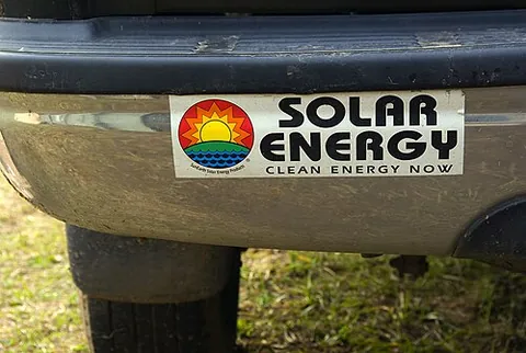 bumper sticker: an adhesive label or decal, usually applied to the bumper or back end of an automobile, and...