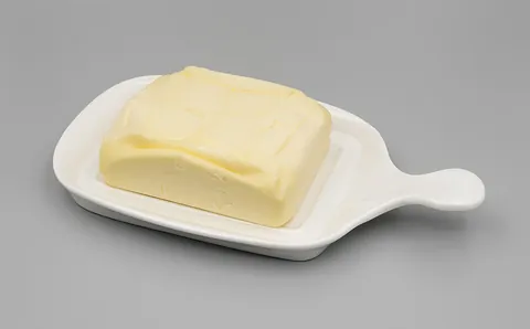 butter: a soft, fatty foodstuff made by churning the cream of milk (generally cow's milk)