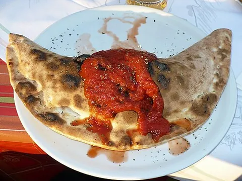calzone: a baked Italian turnover made of pizza dough and stuffed with tomato, cheese and other toppings
