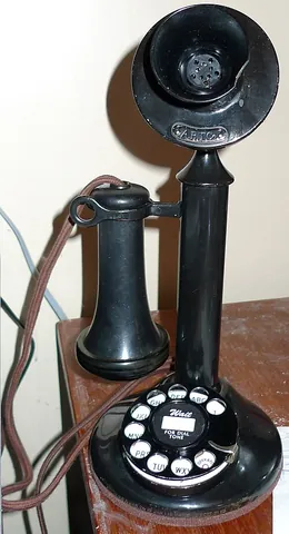 candlestick telephone: an early style of telephone with a mouthpiece (transmitter) mounted at the top of its stand, and a...