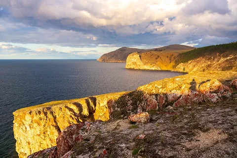 cape: a piece or point of land, extending beyond the adjacent coast into a sea or lake; a promontory; a...