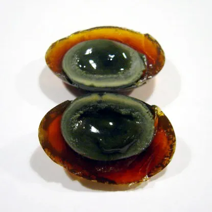 century egg: a Chinese delicacy made by preserving a duck, chicken or quail egg in a mixture of clay, ash, salt,...