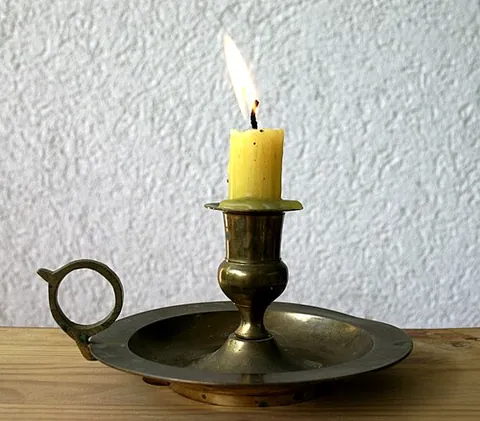 chamberstick: a short candlestick with a pan at the base to catch dripping wax