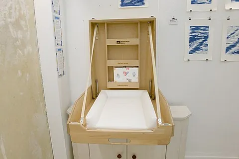 changing table: a small raised platform designed to allow a person to change someone's diaper