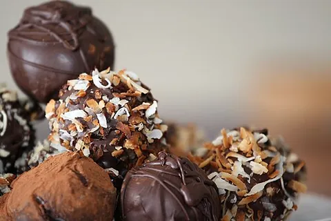 chocolate truffle: a confection having a center of ganache and an outer coating of powdered cocoa or chocolate
