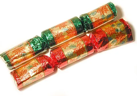 christmas cracker: a table decoration, in the form of a large paper sweet wrapper, constructed around a cardboard tube...