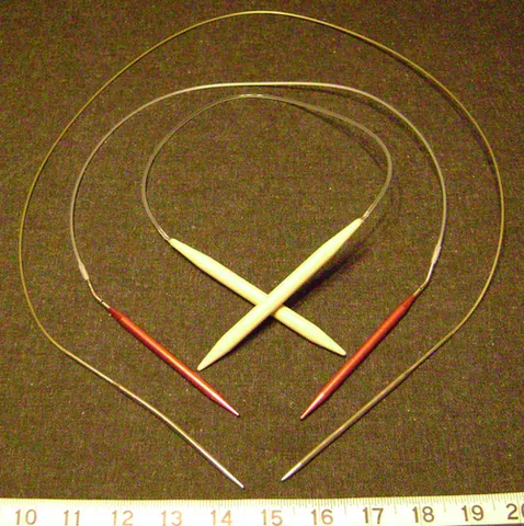 circular needle: a knitting implement consisting of two needles connected by a thin wire; used to knit round tubes