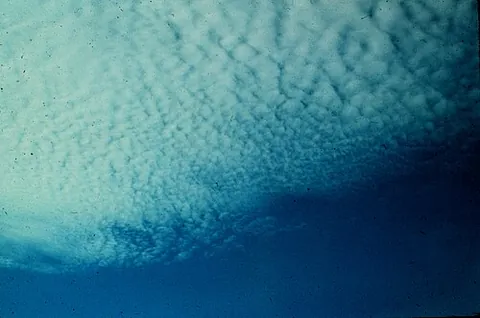 cirrocumulus: a principal high-level cloud type appearing as a thin, white patch of cloud without shadows,...