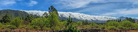 cloudfall: the flow of a cloud over a mountain ridge or cliff