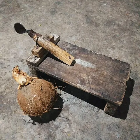 coconut grater: a stool equipped with a spike attached to a handle, used for manual grating or scraping of meat...