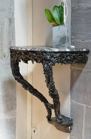 console table: a wall-mounted table whose top is supported by two or more consoles (brackets) instead of legs