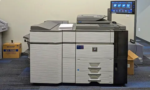 copier: a machine that copies graphical material; a duplicator