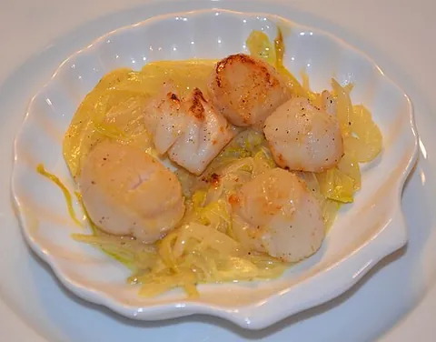 coquille: a meal, especially a seafood dish, served in an actual scallop shell or a dish (container) shaped...