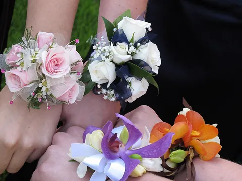 corsage: a small bouquet of flowers, originally worn attached to the bodice of a woman's dress