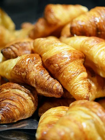 croissant: a flaky roll or pastry in a form of a crescent