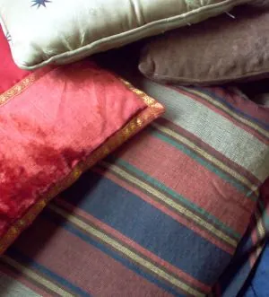 cushion: a soft mass of material stuffed into a cloth bag, used for comfort or support