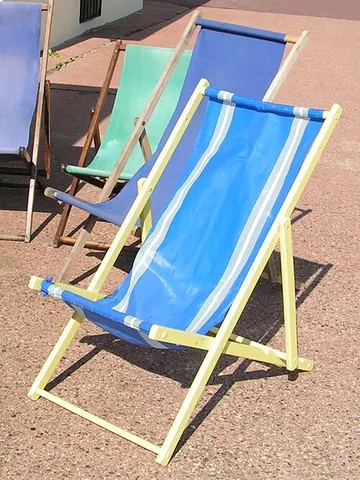 deck chair: a folding chair in which a wooden frame supports a length of canvas; traditionally used on the...