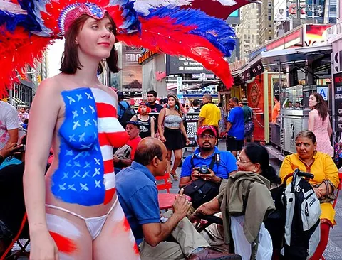 desnuda: a topless female street performer covered in body paint who poses for photographs in exchange for...