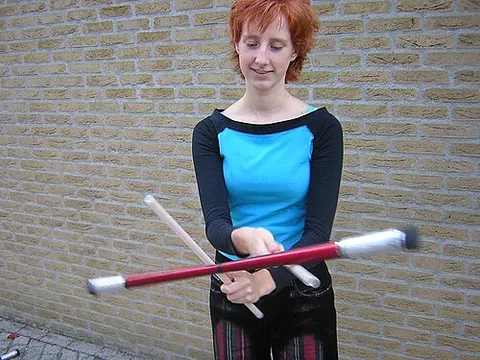 devil sticks: a juggling prop consisting of two hand or control sticks (dowels) and a third larger,...