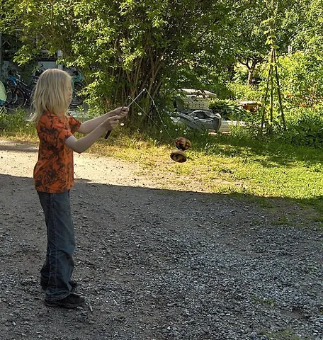 diabolo: a juggling apparatus consisting of a spool which is whirled and tossed on a string attached to...