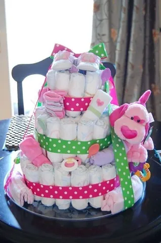 diaper cake: a collection of diapers and related childcare items stacked together in the shape of a cake and...
